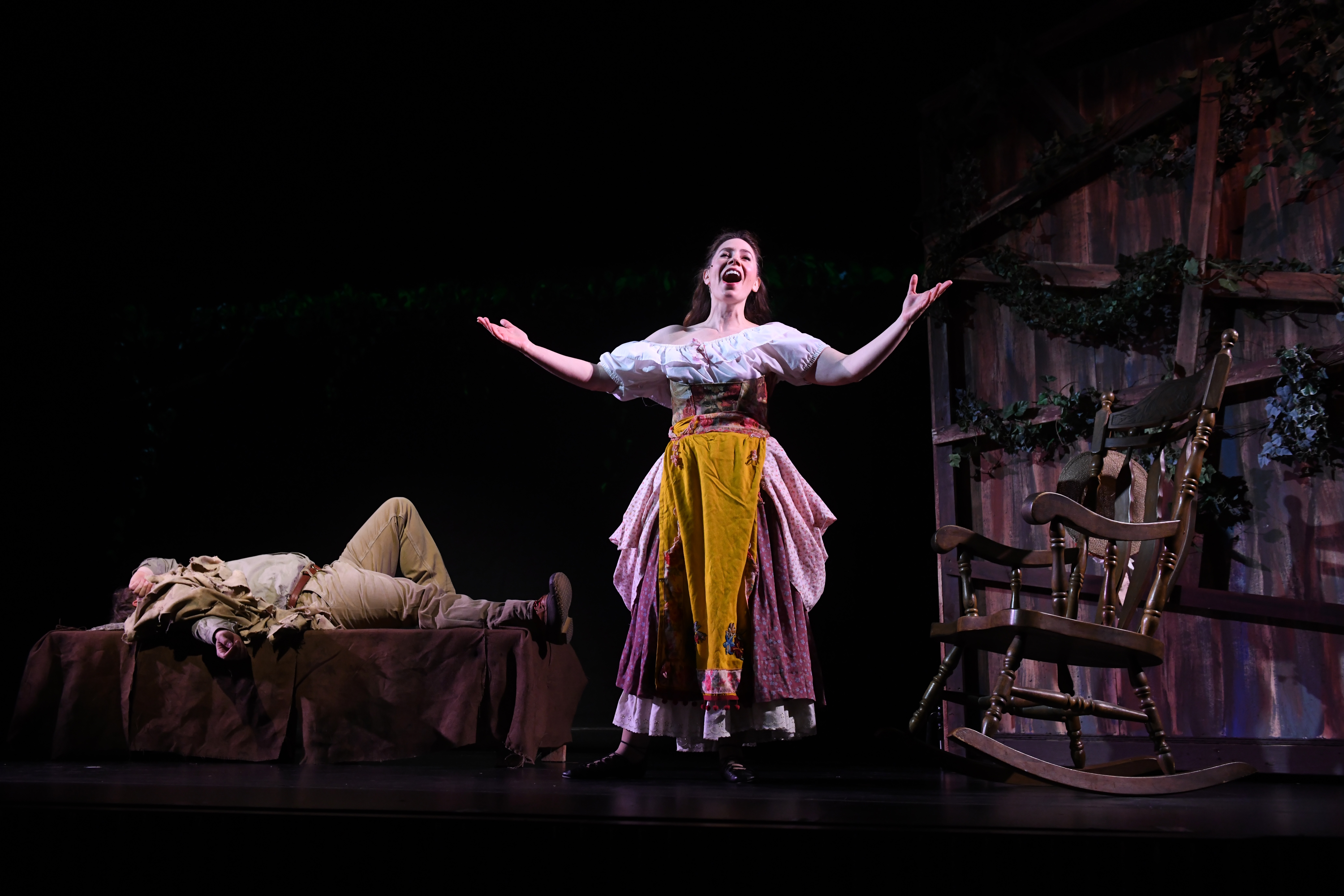 actress singing in front of a shed